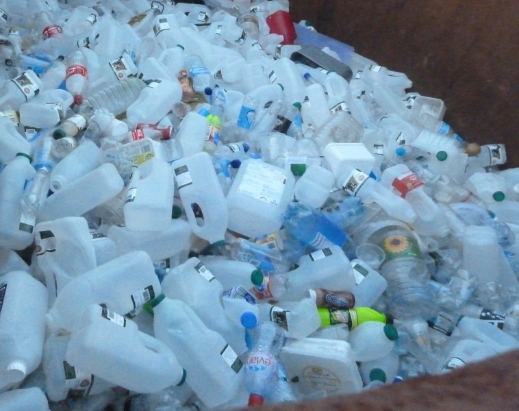 A large pile of empty plastic milk containers